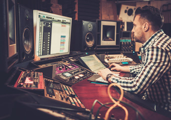 Sound engineer working at mixing panel in the boutique recording