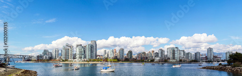 Fotografía panoramic view of the buildings of vancouver city skyline behind a marina during