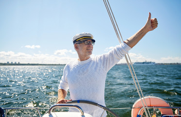 Canvas Print - senior man at helm on boat or yacht sailing in sea