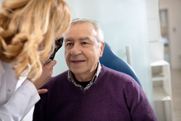 Senior looks into instrument for checking eyes