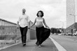 Beautiful pregnant couple walking hand in hand black and white