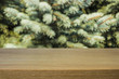 image of wooden table in front of abstract blurred background of firtree