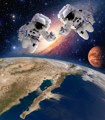 Wall Mural - two astronauts spaceman planet spacewalk outer space walk moon mars galaxy. elements of this image f
