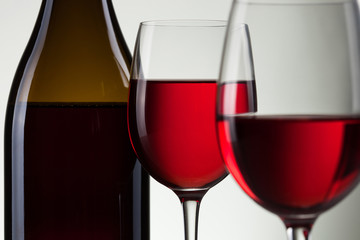 Glass of wine and bottle on white with copy space