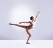© Acronym - Athletic ballet dancer in a perfect shape performing over the grey background.
