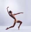 © Acronym - Athletic ballet dancer in a perfect shape performing over the grey background.