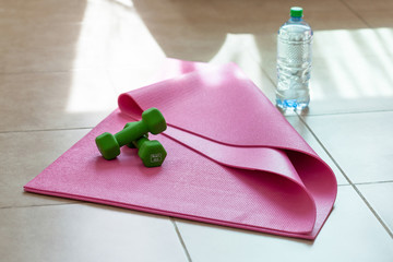 Wall Mural - Two  dumbbells with mineral water on  yoga mat