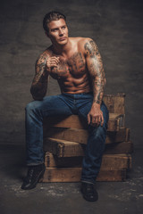 Wall Mural - Shirtless muscular man with tattooes on his body.