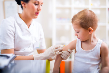 Pediatrician makes vaccination to small boy