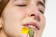© Alonso Aguilar - Close up of a young woman with a nose ring and a small flower in her mouth