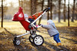Toddler boy playing with his stroller at the warm spring day