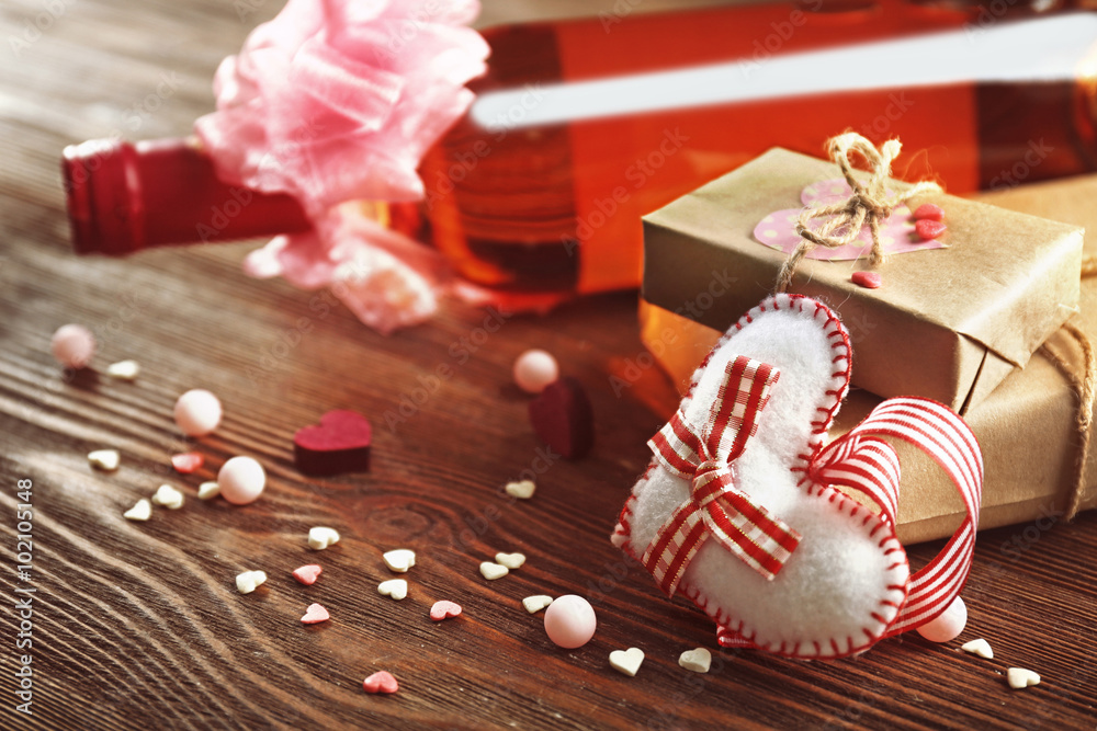 Red wine bottle and gift box on wooden background