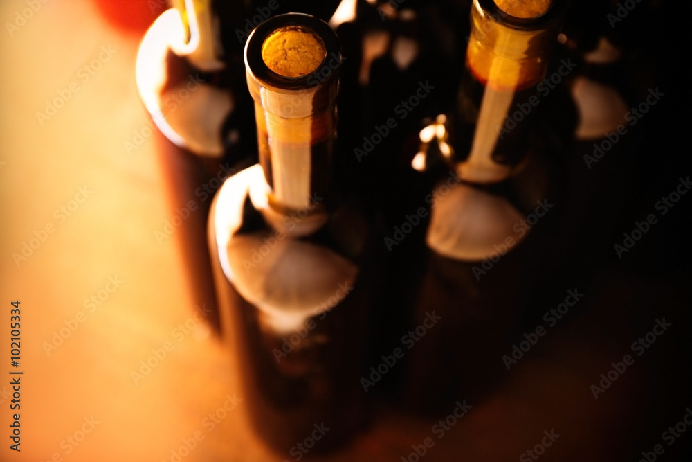 Stacks of wine bottles on wooden background, upside view. Close up