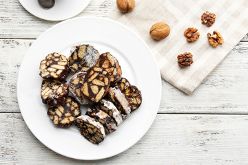 Sticker - Chocolate salami in a plate over wooden background, close up