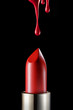 Red melting lipstick isolated on black background