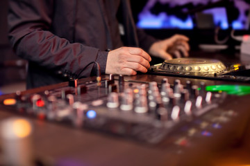 DJ mixing music on console at the night club