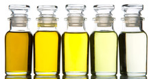 Avocado Fruit Oil, Sesame Seed Oil, Olive Oil, Grape Seed Oil And Corn Oil In Vial Glass Bottle Over White Background