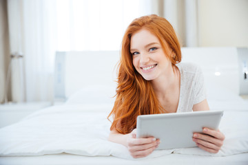 Sticker - Woman lying on the bed with tablet computer