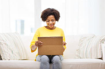 Poster - happy african young woman with parcel box at home