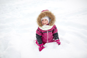 f happy little child or girl with snow in winter