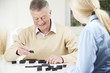 © highwaystarz - Senior Man Playing Dominoes With Teenage Granddaughter