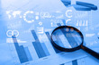 © tonefotografia - Magnifying glass and documents with analytics data lying on tabl