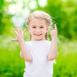 © Mila May - Beautiful blond little girl with two braids  showing six fingers (her age) and smiling on sunny day in summer park