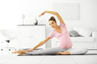Health concept. Young beautiful pregnant woman does yoga exercise in the modern room
