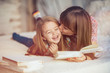 © sergiubirca - Portrait of a smiling young cute mother and daughter reading a book lying and relax in the bed in a bright big white room