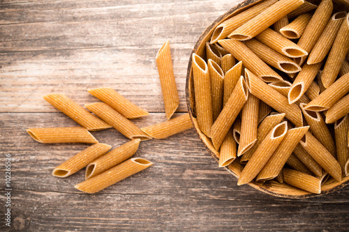Fotografie, Obraz Macaroni on the bowl, wooden background.