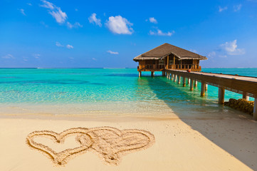 Drawing connected hearts on beach