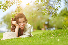 Beautiful Smiling Woman Lying On A Grass Outdoor. 