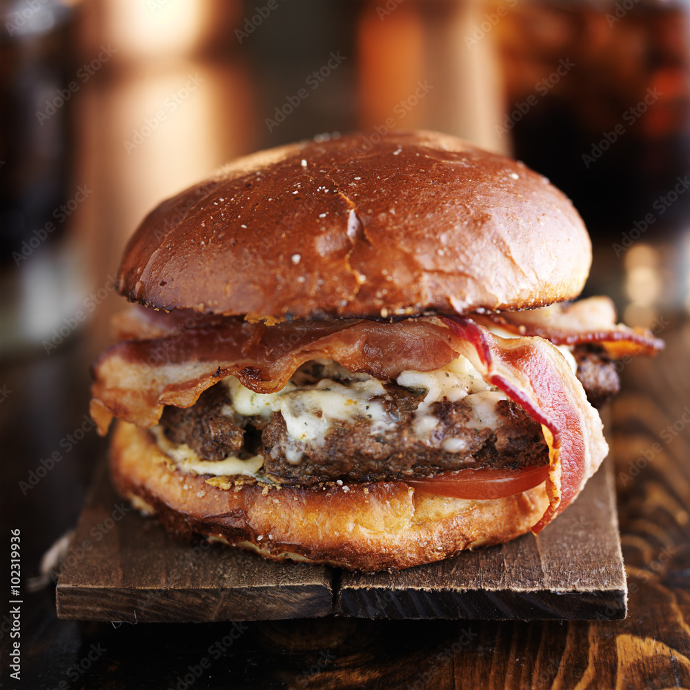 big juicy burger with bacon and melted pepper jack cheese - obrazy, fototapety, plakaty 