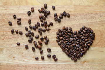 coffee beans in heart shape on wooden panel