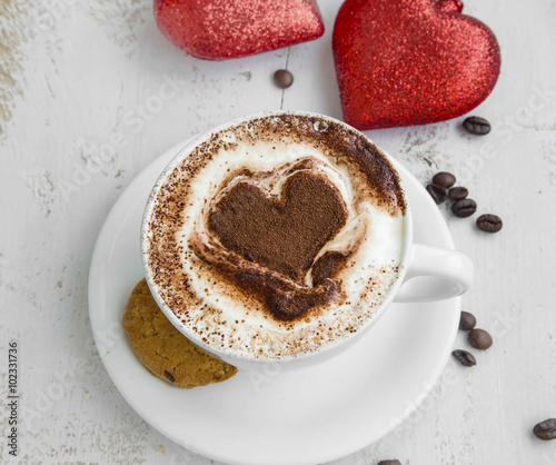 Fototapeta na wymiar Cappuccino latte coffee with cocoa heart-shape and cookies