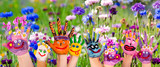 Fototapeta  - Ausgelassenheit, Glück, Freude: Hände spielender Kinder vor Wiese mit bunten Kornblumen :)