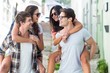 © WavebreakMediaMicro - Hip men giving piggy back to their girlfriends