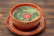typical portuguese soup caldo verde in ceramic dish on brown wooden background
