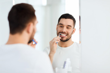 Wall Mural - man with toothbrush cleaning teeth at bathroom