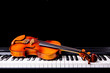 Violin on the piano on a black background