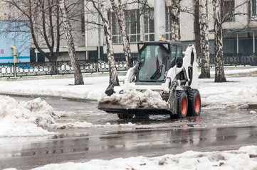 loader removes snow on city streets