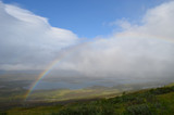Fototapeta Tęcza - Clouds, rainbow and sunshine over valley in subarctic mountains, Swedish Lapland