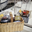 Food items with tableware in picnic basket on sailboat