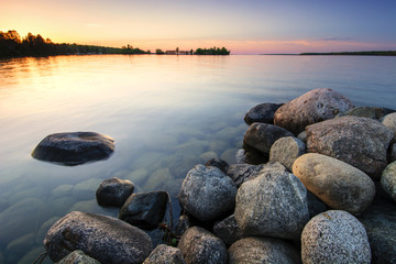 Large boulders on lake shore at sunset. Minnesota, USA