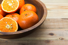 Fresh Oranges In Wooden Bowl. On A Wooden Background.