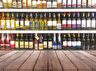 Wall Mural - Wood table and wine Liquor bottle on shelf Blurred background