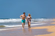 © gawriloff - Couple Running Through Waves On Beach Holiday