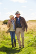© micromonkey - Senior Couple Walking In Countryside Together