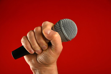 Man hand with microphone over red background