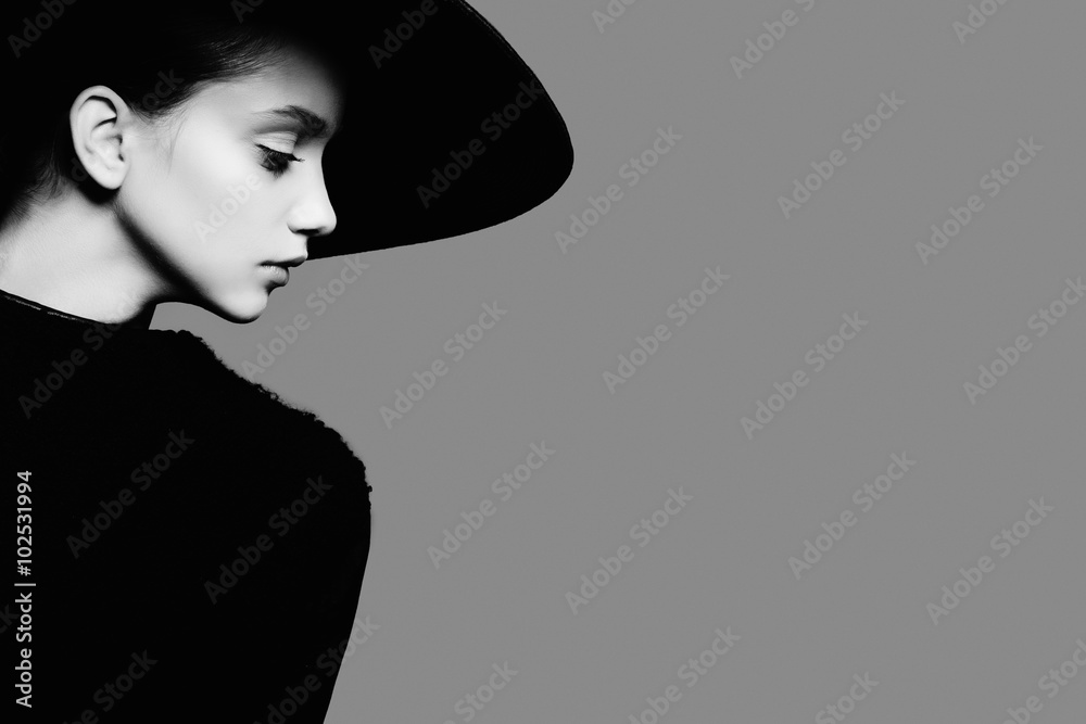 Portrait of beautiful girl in hat in profile, posing in studio, black and white photography - obrazy, fototapety, plakaty 